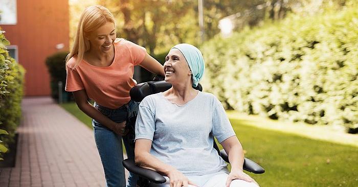 Woman with illness being pushed in a wheelchair