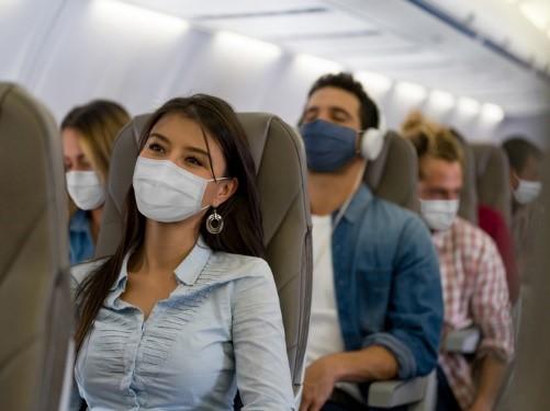 Masked people sitting on a plane
